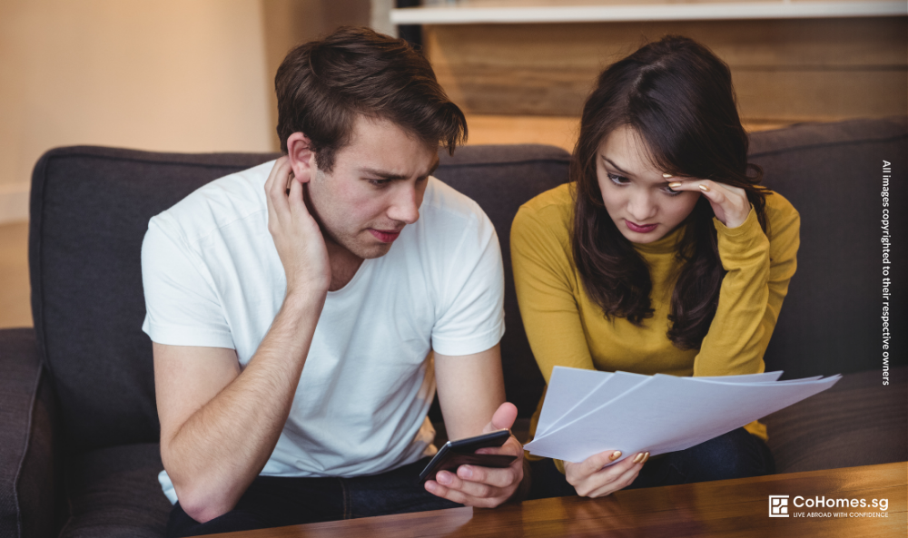 Couple reviewing documents and rental details with a stressed expression, highlighting decision-making regrets in renting.
